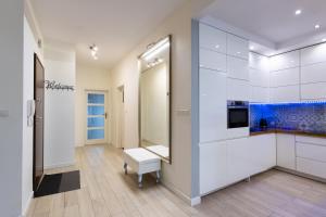 a bathroom with white cabinets and a blue aquarium at Cinema Flat Centrally Located in Warsaw