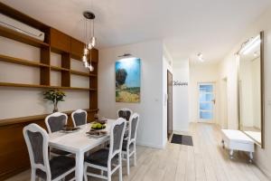 a dining room with a white table and chairs at Cinema Flat Centrally Located in Warsaw