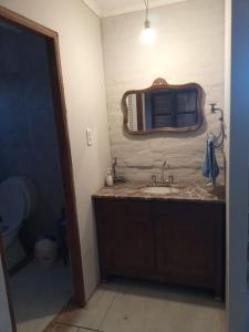 een badkamer met een wastafel en een spiegel aan de muur bij Hermosa Casa en Paso de la Patria in Paso de la Patria