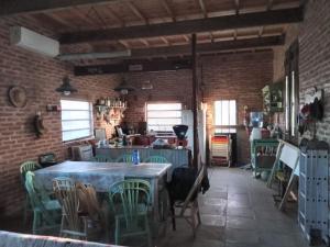 een kamer met tafels en stoelen in een bakstenen muur bij Hermosa Casa en Paso de la Patria in Paso de la Patria