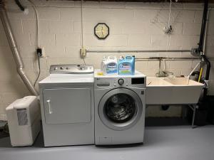 een wasmachine en een wastafel in een wasruimte bij M1 Queen Size BedRoom with desk near Rutgers U & hospitals in New Brunswick