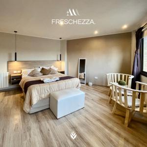 a bedroom with a large bed and two chairs at Agrippina in Villa Carlos Paz