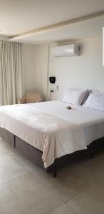 a large white bed in a white room with at Flat beira mar do Cabo Branco in João Pessoa