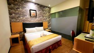 新山的住宿－GODORI HOTEL SDN BHD，一间卧室设有一张床和砖墙