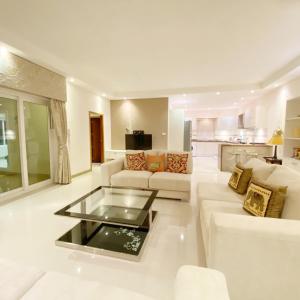 sala de estar con muebles blancos y mesa de cristal en Sunny3 villa Pattaya, en Ban Huai Yai