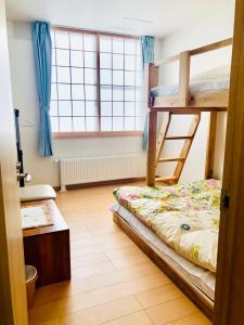 小樽市にあるOtaru Garden Stayのベッドルーム1室(二段ベッド2台、窓付)が備わります。