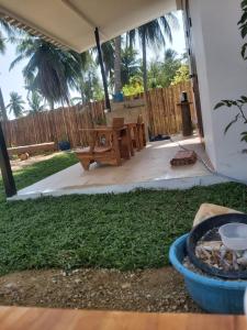 a patio with a wooden table and a bench at Nice Home Stay @Samroiyot in Sam Roi Yot