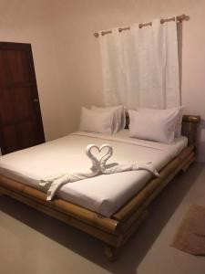 a bed with a heart decoration on it at Nice Home Stay @Samroiyot in Sam Roi Yot