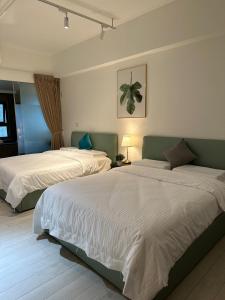 2 Betten in einem Hotelzimmer mit in der Unterkunft Spring溫泉 in Toucheng