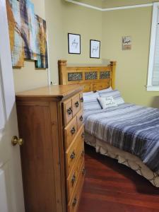 a bedroom with a wooden dresser and a bed at Mid City Fun in New Orleans