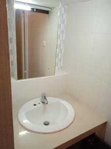 ein Badezimmer mit einem weißen Waschbecken und einem Spiegel in der Unterkunft NEW KUBU DI BUKIT in Jimbaran