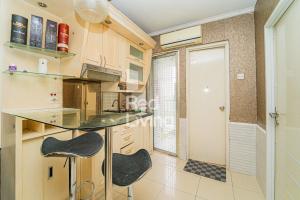 a kitchen with a counter and two chairs in it at RedLiving Apartemen Kalibata City - Homy Jasen Tower Jasmine in Jakarta