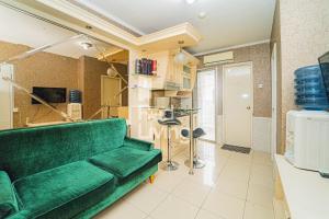 a living room with a green couch in a room at RedLiving Apartemen Kalibata City - Homy Jasen Tower Jasmine in Jakarta