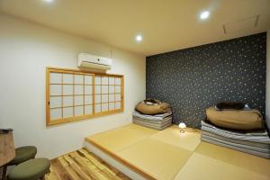 a room with a wall with a window and some blankets at Villa Kyoto Saiin in Kyoto