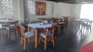 a dining room with tables and chairs in a restaurant at Hotel Wisma Mangurna in Doloksanggul