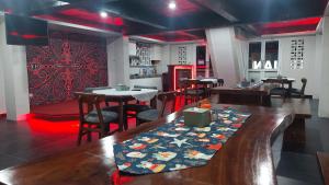 a restaurant with a long table and tables and chairs at Hotel Wisma Mangurna in Doloksanggul