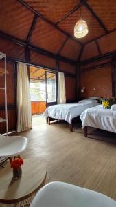 a large room with two beds and a table at Kelimutu Paradiso Resort in Kelimutu