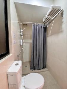 a bathroom with a toilet and a shower curtain at Bayu 23 Hotel in Kota Kinabalu