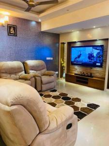 a living room with white furniture and a flat screen tv at Lovely 2bed room AC apartment JP Nagar in Bangalore