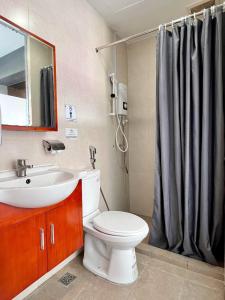 y baño con aseo, lavabo y ducha. en Bayu 23 Hotel en Kota Kinabalu