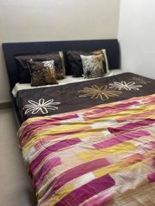 Una cama con una manta colorida y almohadas. en Lovely 2bed room AC apartment JP Nagar, en Bangalore
