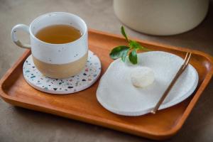 H& Yu Krung Style Inn في مدينة تايتونج: كوب من الشاي على صينية مع صحن