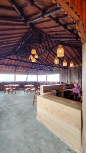 uma grande sala com mesas, cadeiras e luzes em Kelimutu Paradiso Resort em Kelimutu