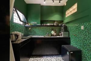 een groene keuken met een zwart aanrecht en groene tegels bij Ancient villa 108m2 duplex next to Hoan Kiem Lake! in Hanoi
