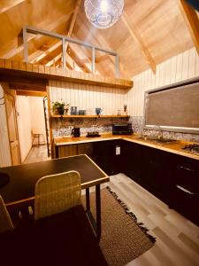 uma cozinha com uma mesa e uma televisão num quarto em Colico Tiny Lodge - jacuzzi-Terraza em Catrico