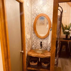uma casa de banho com um lavatório e um espelho em Colico Tiny Lodge - jacuzzi-Terraza em Catrico