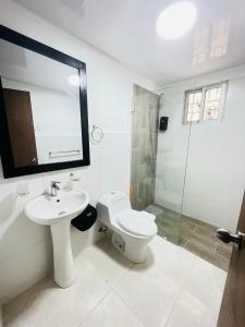 uma casa de banho com um WC, um lavatório e um chuveiro em Beautiful Condo in La Romana with pool near Caleta Beach em La Romana