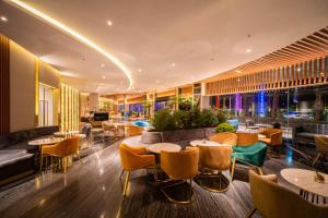 a hotel lobby with tables and chairs and a bar at Pentacity Hotel Balikpapan in Balikpapan