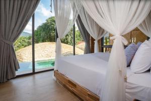 a bedroom with a bed with a view of a pool at Three Monkeys Villas in Patong Beach