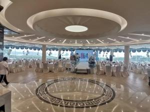 um salão de banquetes com mesas e cadeiras numa sala em 无锡花园大酒店 em Wuxi