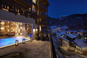 a building with a swimming pool at night at La Vue Luxury Living Apartments in Zermatt