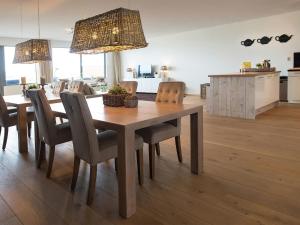 una cucina e una sala da pranzo con tavolo e sedie in legno di Sea view Apartment in Den Haag with Balcony a Scheveningen