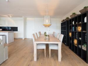 una sala da pranzo con tavolo e sedie bianchi di Sea view Apartment in Den Haag with Balcony a Scheveningen