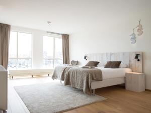 una camera bianca con un letto e una grande finestra di Sea view Apartment in Den Haag with Balcony a Scheveningen