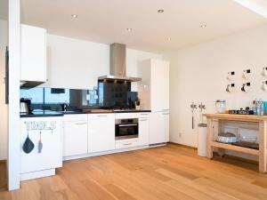 een keuken met witte kasten en een houten vloer bij Modern apartment in the harbor of Schevening in Scheveningen