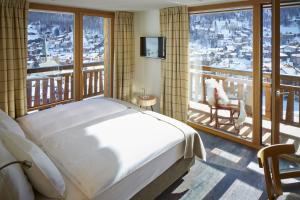 una camera da letto con un letto e una grande finestra di La Vue Luxury Living Apartments a Zermatt