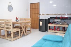 a living room with a wooden table and a kitchen at Flat JACUMÃ LITORAL SUL PB in Jacumã