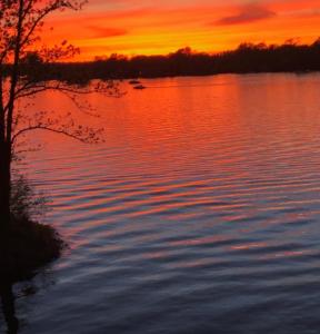 zachód słońca nad dużym zbiornikiem wody w obiekcie Luxury on the lake w mieście Indianapolis