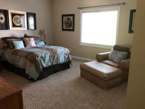 a bedroom with a bed and a chair and a window at Luxury on the lake in Indianapolis