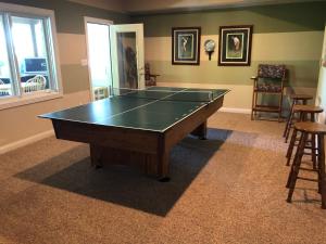 uma mesa de ping pong numa sala de estar com ahibition em Luxury on the lake em Indianápolis