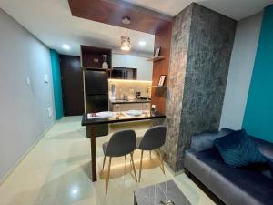 a kitchen with a table and a couch in a room at Dpto lujoso, comodo e intimo cerca de todo in Santa Cruz de la Sierra