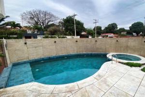 a swimming pool next to a brick wall at Dpto lujoso, comodo e intimo cerca de todo in Santa Cruz de la Sierra