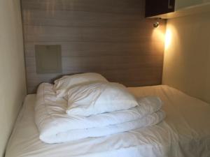 a bed with white sheets and pillows on it at Studio lumineux avec parking et petits animaux acceptés - 4 personnes - FR-1-198-115 in Châtel