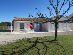 mały domek z czerwonym parasolem i drzewem w obiekcie Maison de Vacances 4 pièces avec Jardin Clos, Proche Port et Plage - 6 Couchages à Saint-Pierre-d'Oléron - FR-1-246A-171 w mieście Saint-Pierre-dʼOléron