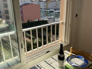 butelka wina na stole obok okna w obiekcie T2 avec ascenseur, parking proche plage - FR-1-702-21 w Cap d'Agde