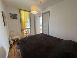sypialnia z łóżkiem i dużym oknem w obiekcie T2 avec ascenseur, parking proche plage - FR-1-702-21 w Cap d'Agde